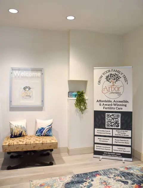 Arbor Fertility welcome nook with bench seating, Arbor banner, and Welcome sign