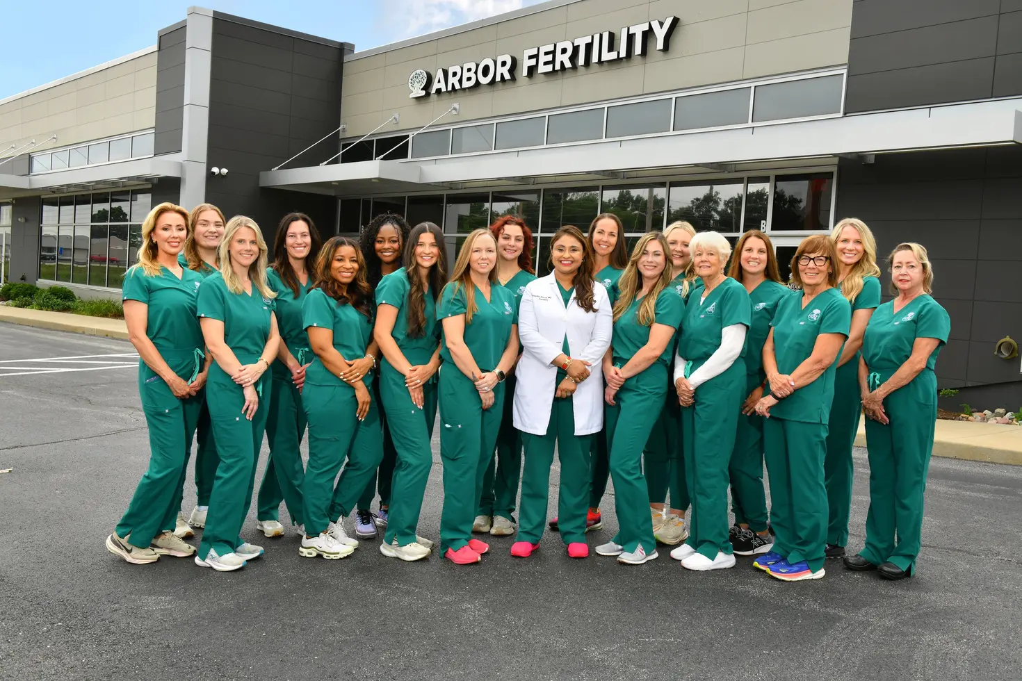 The Arbor Fertility care team in green scrubs with Dr. Shvetha Zarek, standing in front of the Arbor Fertility building in Chesterfield