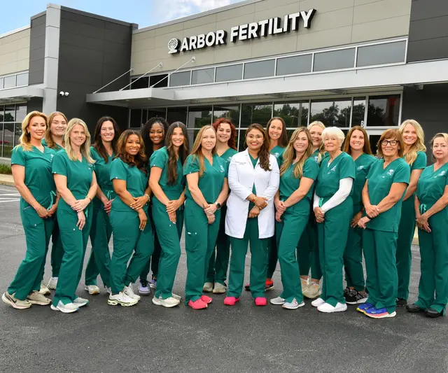 The Arbor Fertility care team in green scrubs with Dr. Shvetha Zarek, standing in front of the Arbor Fertility building in Chesterfield